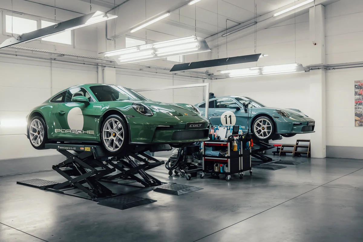 Zwei folierte Porsche 911 GT3 auf Hebebühnen in der CULT Werkstatt