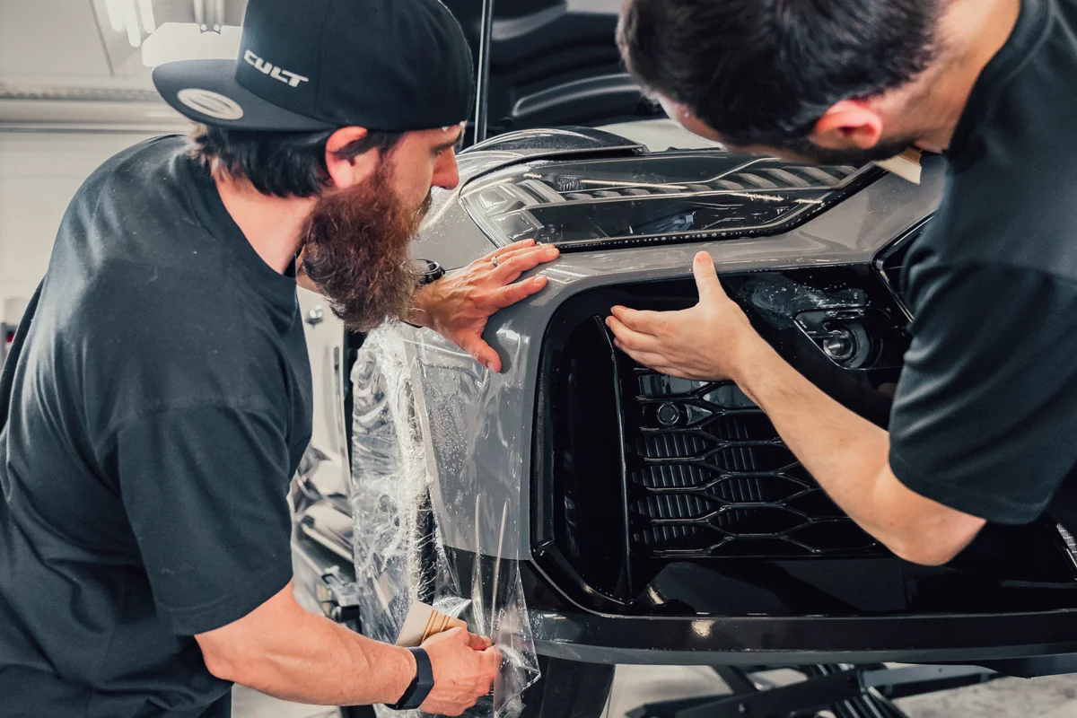 CULT-Techniker bringen Lackschutzfolie an der Front eines Audi RS6 GT an